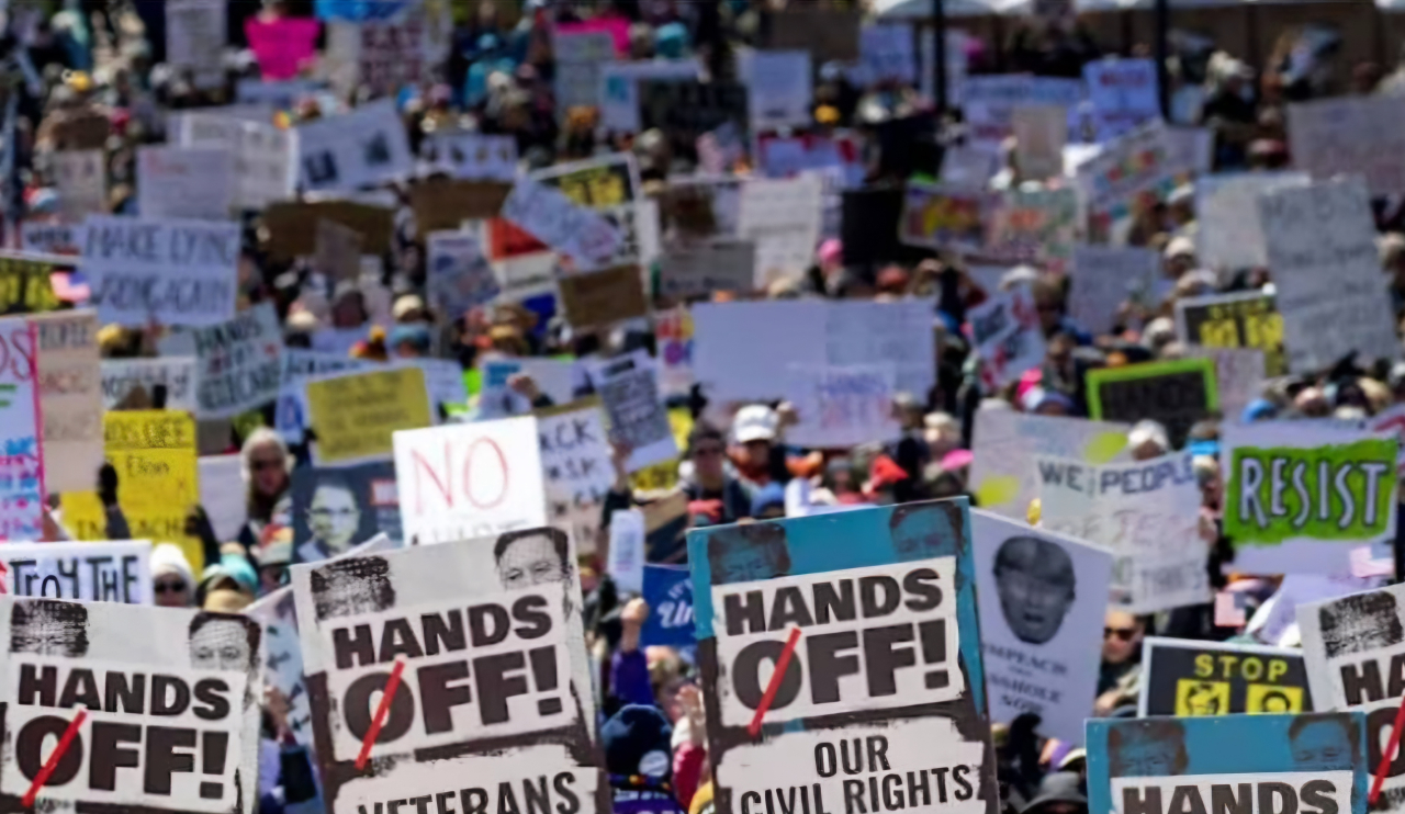 Ribuan warga AS menenteng poster 'Hands Off' mendemo Presiden AS Doland Trump. (Foto: Guardian News)