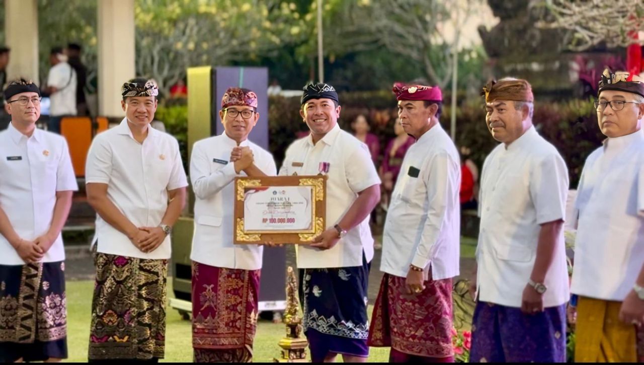 Perbekel Darmasaba Ida Bagus Surya Prabhawa Manuaba saat menerima penghargaan Juara 1 Evaluasi Desa se-Kabupaten oleh Bupati Badung Adi Arnawa 